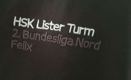 Ein Auschnitt eines schwarzen Hemds mit dem Text "HSK Lister Turm 2. Bundesliga Nord"